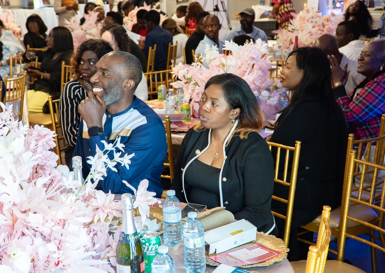 Guests seated together at decorated tables, smiling and listening