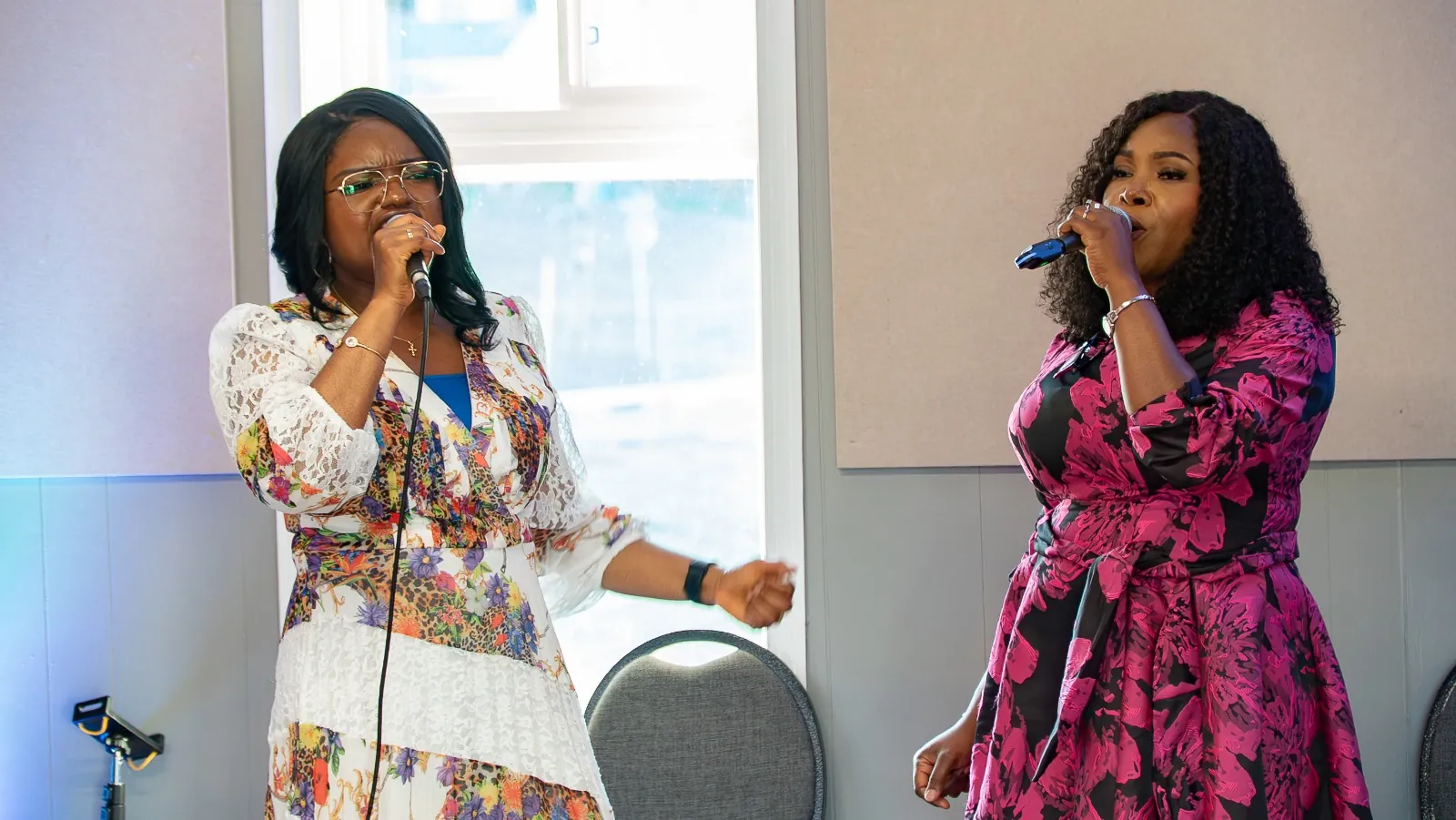 Two women singing together with microphones