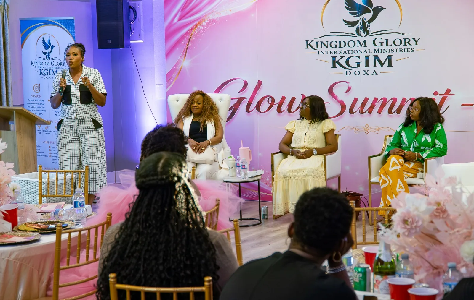 A stage panel at a KGIM gathering beneath the Glow Summit backdrop